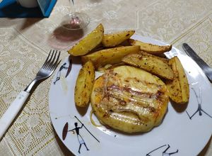 Una foto de Provoleta asada con papas bravas