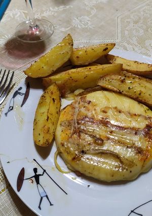 Una foto de Provoleta asada con papas bravas