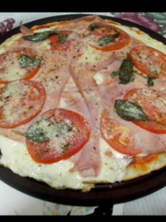 Una foto de Pizza tomate, albahaca, jamón