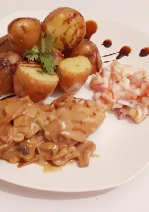 A picture of Jacket potatoes served with chicken in creamy soup.