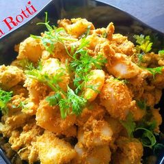 A picture of Kakkarotti - Steamed Rice Dumplings in Spicy Chicken Sauce.
