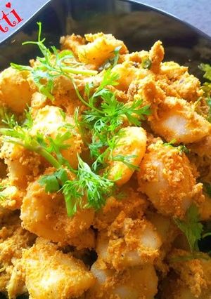 A picture of Kakkarotti - Steamed Rice Dumplings in Spicy Chicken Sauce.