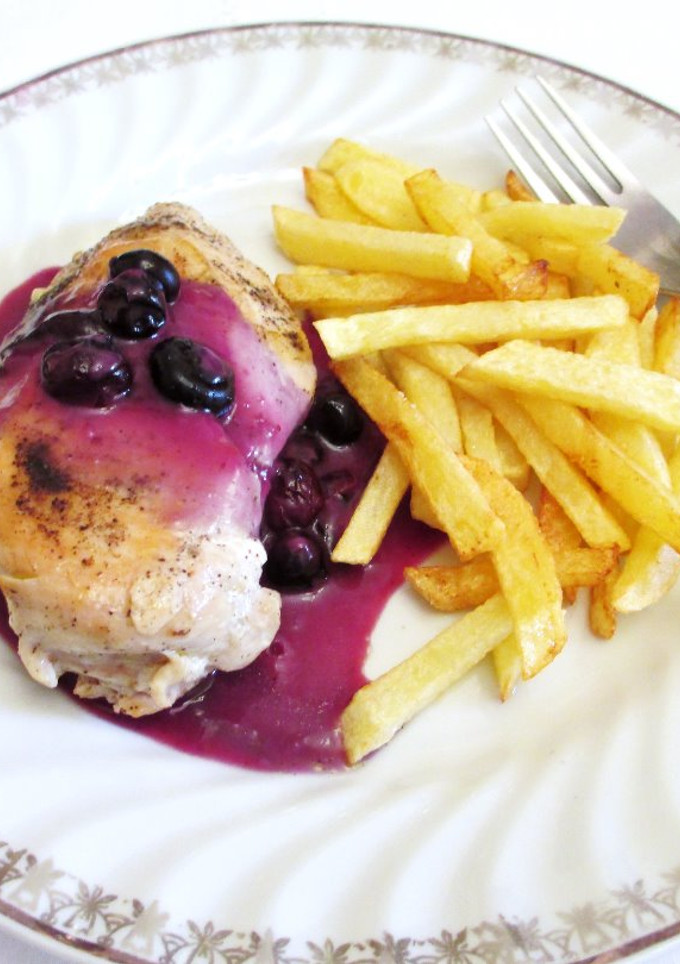 Una foto de Pechuga de pollo bañada con salsa de arándanos y patatas pajas