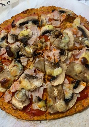 Una foto de Pizza de masa de zanahoria con jamón York, champiñones y queso