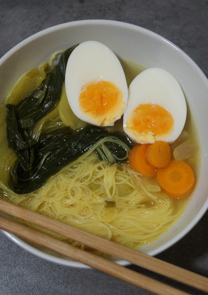 Una foto de Ramen con caldo de pollo, fideos de arroz y pak choi