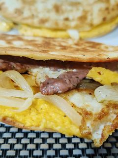 Una foto de Taco burger ibérico con huevo frito y cebolla