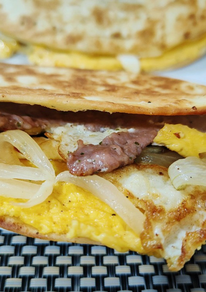 Una foto de Taco burger ibérico con huevo frito y cebolla
