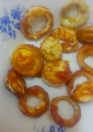 A picture of Boiled eggs in tomato sauce.