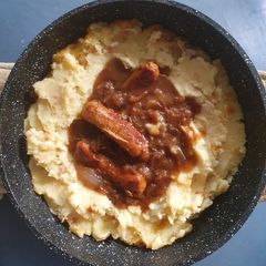 A picture of Bangers an Mash with Beef Gravy and fried Onions.