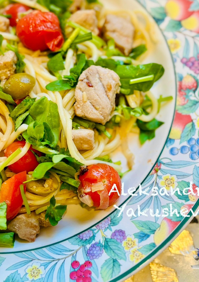 A picture of Spaghetti with tuna, green olives and cherry tomatoes.