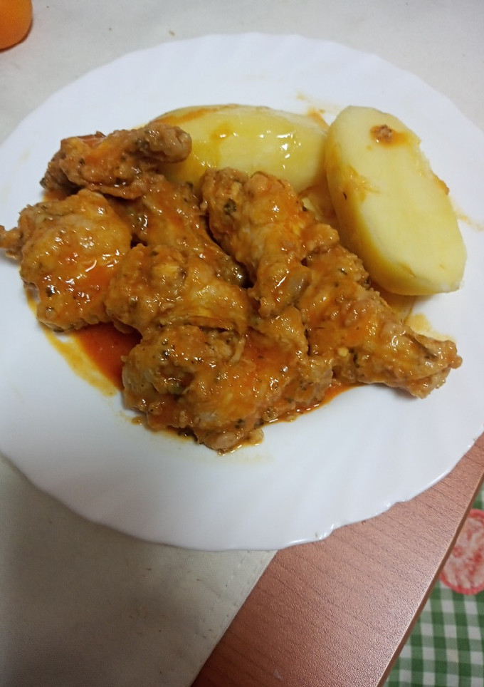 Una foto de Pollo frito en salsa con papas cocidas