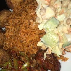 Jollof rice with salad and peppered chicken A picture of Jollof rice with salad and peppered chicken.