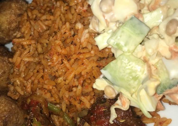 Jollof rice with salad and peppered chicken