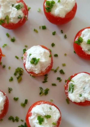 A picture of Pomordorini e caprino cherry tomatoes stuffed with goat's cheese.