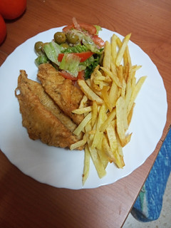 Una foto de Barritas de gallo rebozado con ensalada y papas fritas