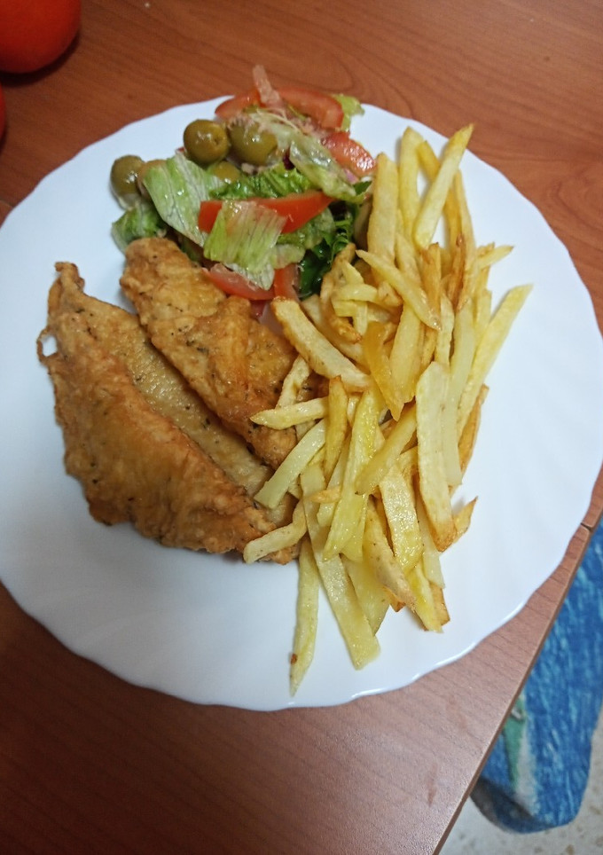 Una foto de Barritas de gallo rebozado con ensalada y papas fritas
