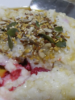 A picture of Brown rice porridge with frozen raspberries.