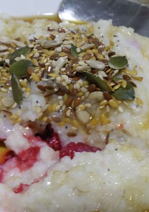 A picture of Brown rice porridge with frozen raspberries.