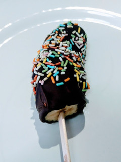 Foto principal de Plátanos helados con cobertura de chocolate y virutas de colores