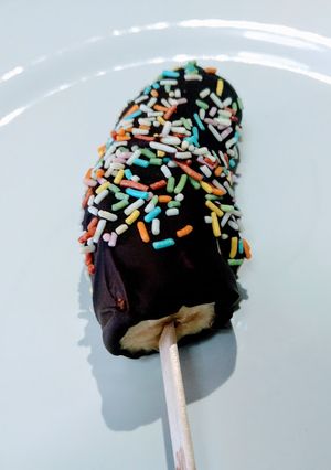 Una foto de Plátanos helados con cobertura de chocolate y virutas de colores