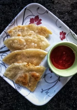 A picture of Aloo ke parathe with tomato chutney.
