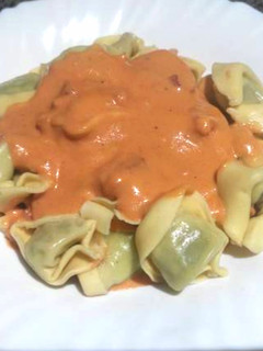 Una foto de Tortellinis rellenos con salsa de tomate, nata y bacon
