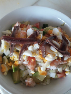 Una foto de Ensalada de patata, langostino, anchoas y aguacate
