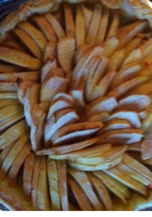 Une photo de Tarte aux pommes sur lit de sucre de coco et framboises