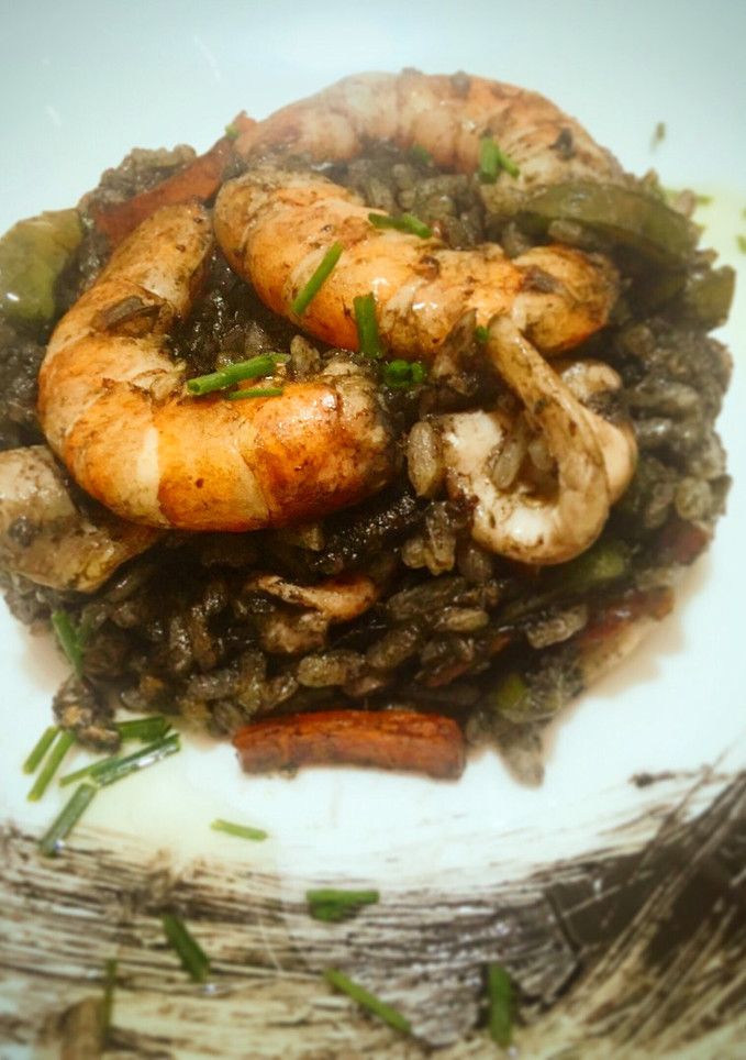 Una foto de Arroz negro salteado con calamar y Gambon