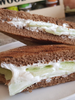 Una foto de Emparedado (bocatta) de pan de centeno con queso crema y pepino