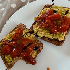 A picture of Avocado toast with fried tomatoes.