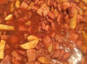 Una foto de Chuleta ahumada con papas en salsa roja