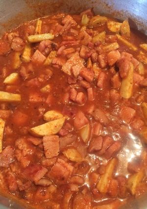 A picture of Smoked Pork Chops with Potatoes in Red Sauce.