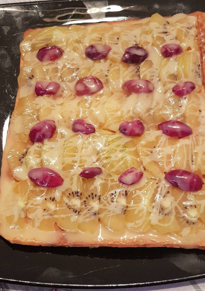 Una foto de Hojaldre con kiwi uvas y chispas de chocolate blanco
