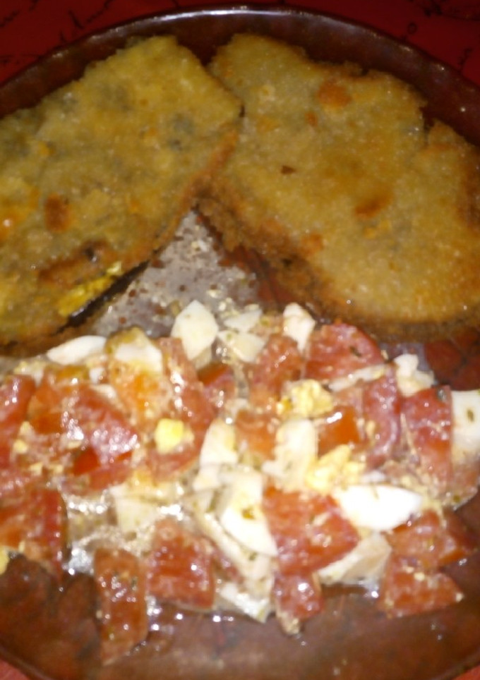 Una foto de Milanesas de berenjena y ensalada de tomate y huevo 😅😅