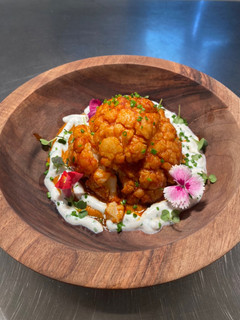 Una foto de Coliflor al vapor con curry rojo y tzatziki