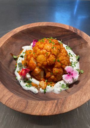 Una foto de Coliflor al vapor con curry rojo y tzatziki