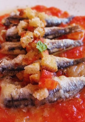 Una foto de Boquerones en escabeche con tomate y pan frito