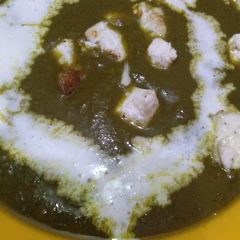 A picture of Palak paneer with onion and garlic.