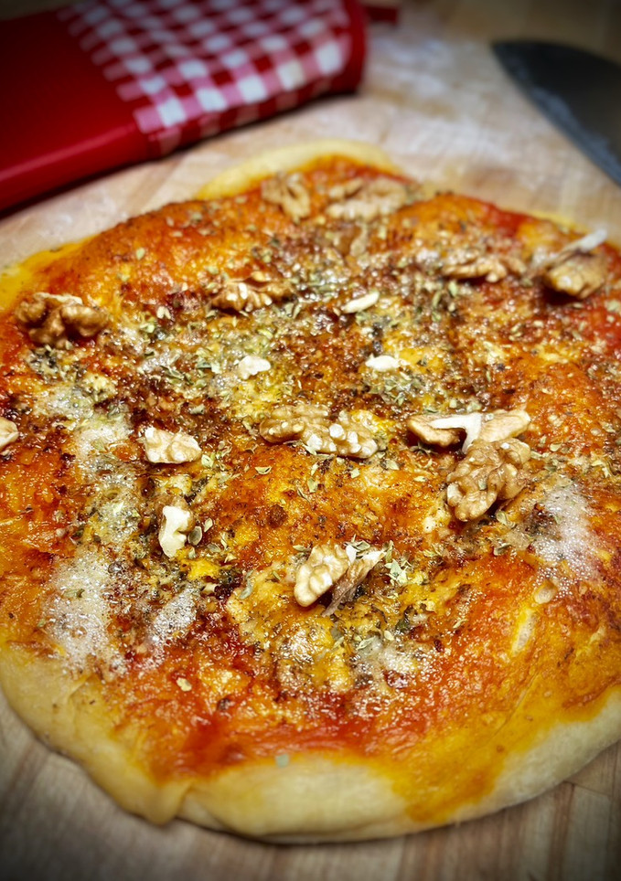Una foto de Pizza casera de Cabrales con pesto y nueces