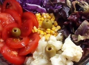 Una foto de Ensalada de coliflor, tomates, choclo y repollo morado
