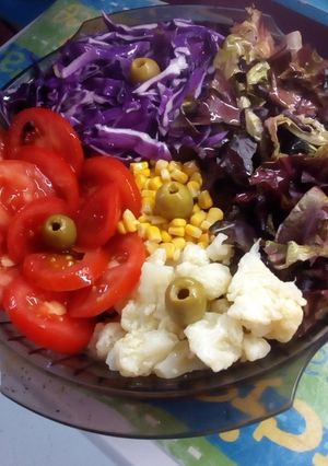Una foto de Ensalada de coliflor, tomates, choclo y repollo morado