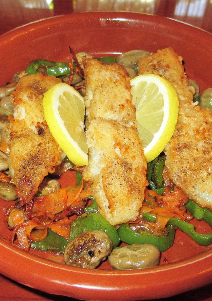 Una foto de Pescado blancosobre habas tiernas con verduras  salteada