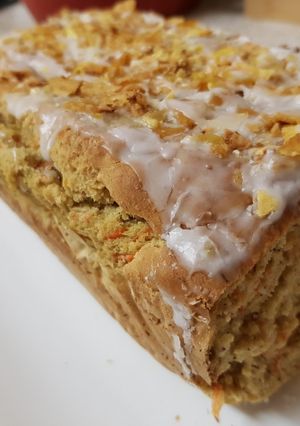 A picture of Carrot & Banana Cake topped with icing and Banana crisp. 😀.