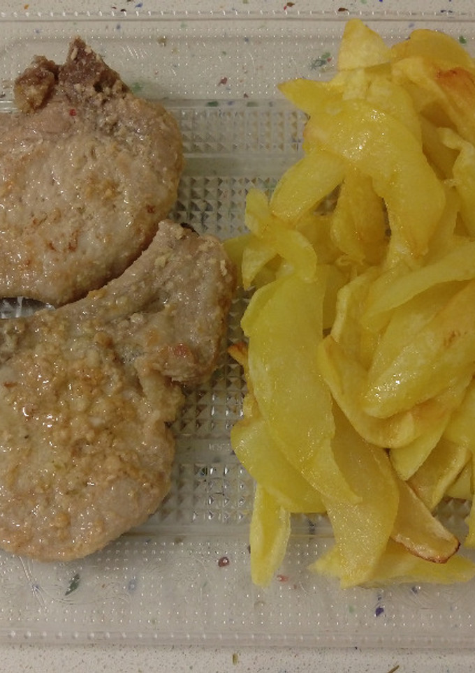 Una foto de Chuletas al ajillo con patatas fritas