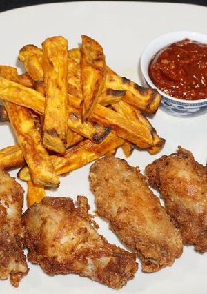 Una foto de Alas de pollo adobadas y bastones de camote amarillo asado