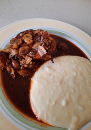 Una foto de Pollo a la coca-cola, champiñones y puré de papa natural