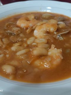 Una foto de Judías blancas con langostinos y chirlas enfadadas