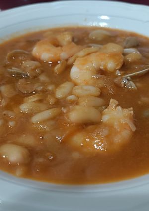 Una foto de Judías blancas con langostinos y chirlas enfadadas