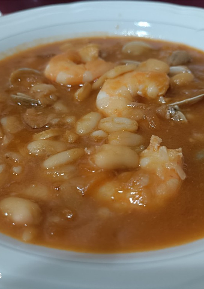 Una foto de Judías blancas con langostinos y chirlas enfadadas